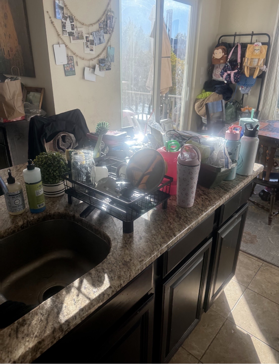 Kitchen counter before cleaning, with dishes and bottles